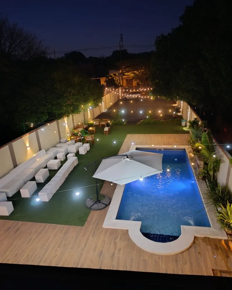 Quinta Ohana de noche con la piscina iluminada y guirnaldas de luces